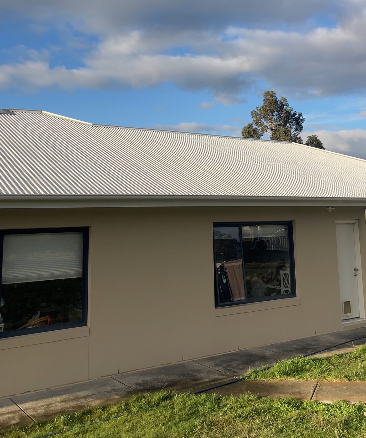 Freshly washed Colorbond roof on a rendered home, Greater Hobart