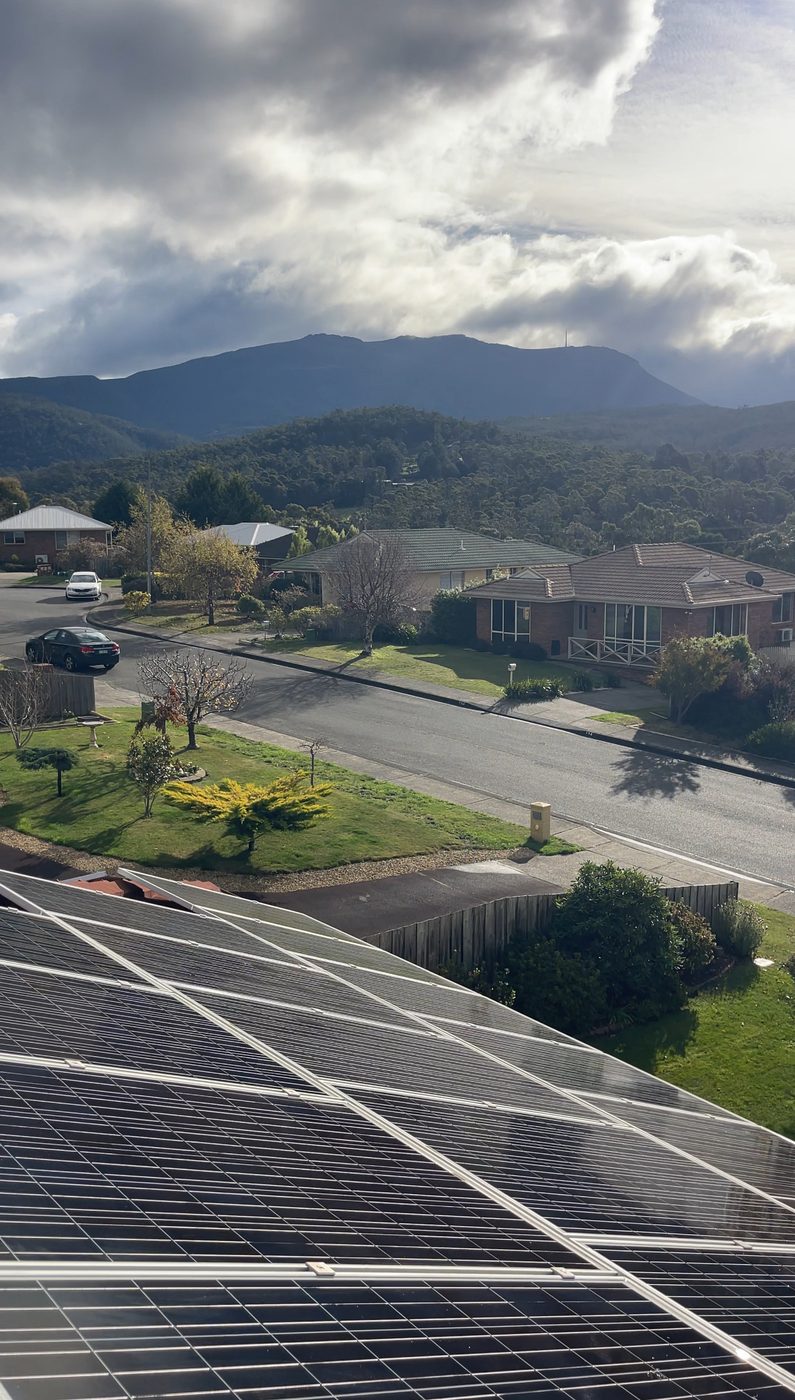 Freshly cleaned solar panels with kunanyi Mount Wellington behind, Hobart