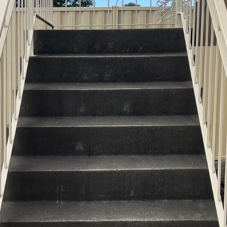 Concrete stairs with cream railings, dark and grimy before pressure washing