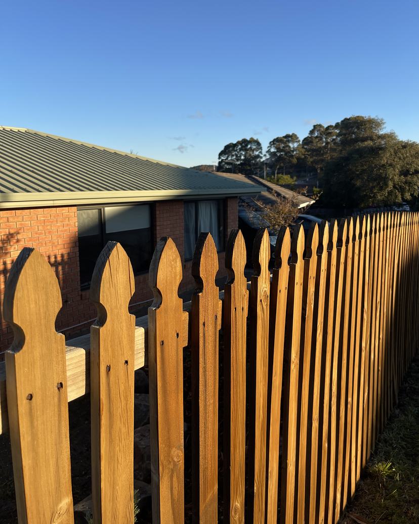 The same timber picket fence after cleaning, golden timber colour back