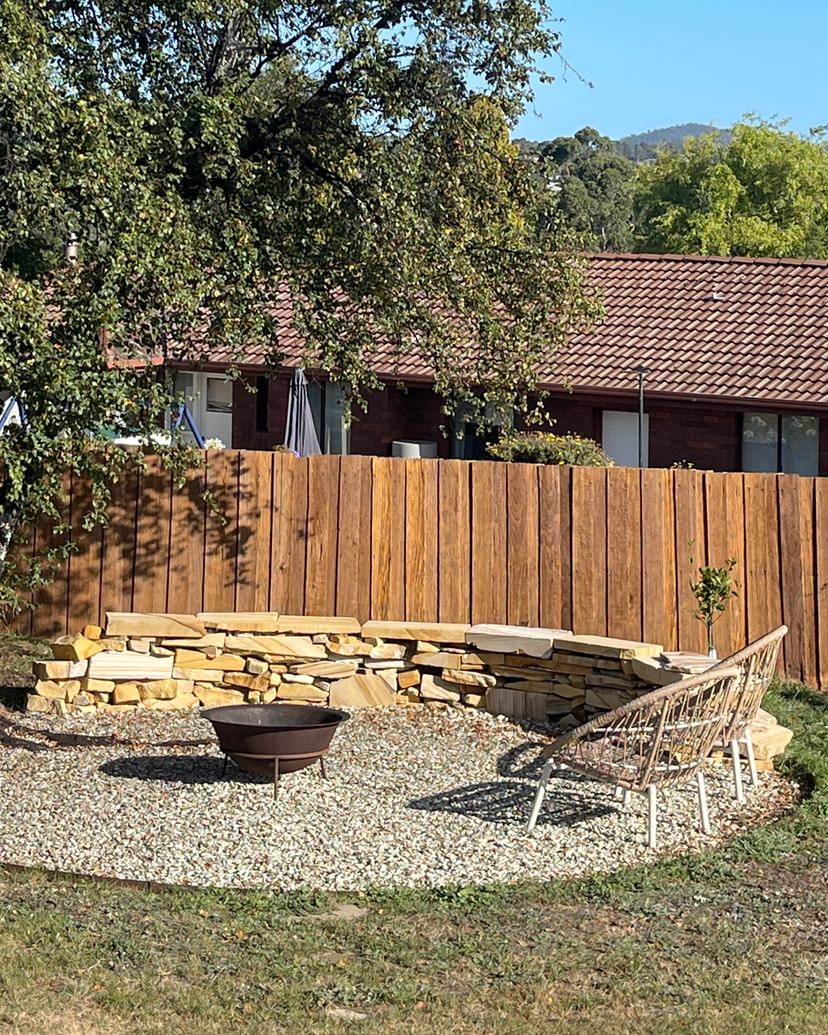 The same fence and sandstone seat wall after cleaning, rich golden timber and stone