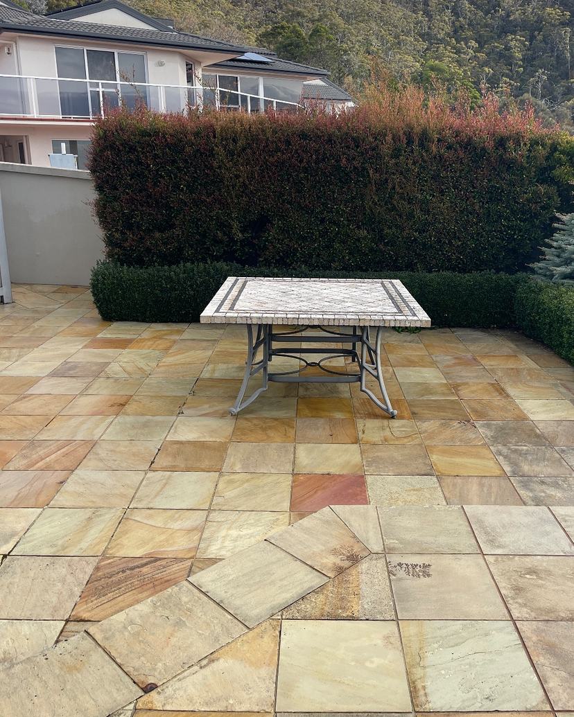 The same Sandy Bay sandstone courtyard after a soft wash, golden stone colour back